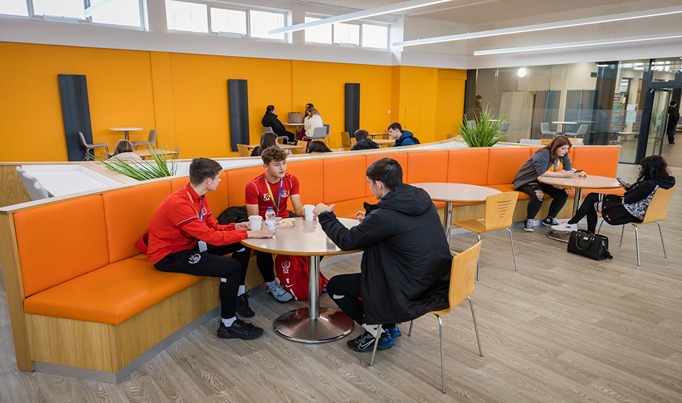 Coleg Cambria students in Deeside canteen eating a free breakfast